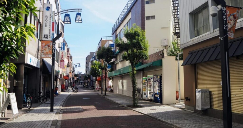 下町の静かな商店街と自動販売機のある通り