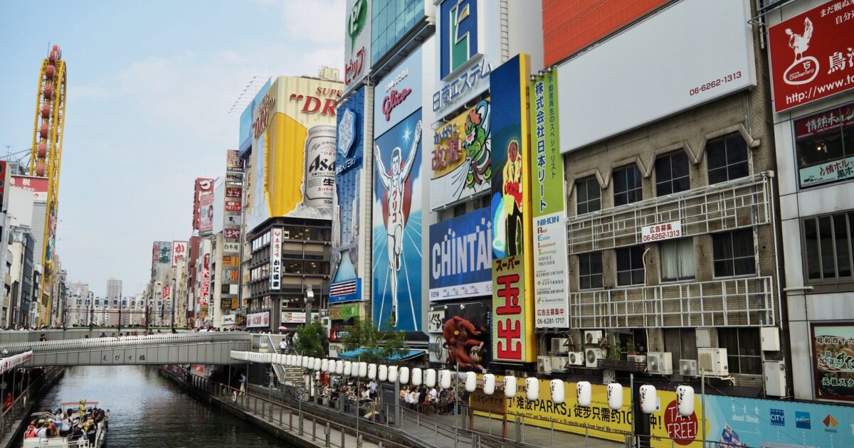 大阪道頓堀のグリコ看板と観光客が行き交う川沿いの風景